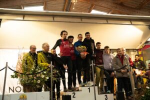 Podium masculin : les trois premiers réunis sur la marche 1, dont deux coureurs en maillot rouge du club ARC Alençon.
