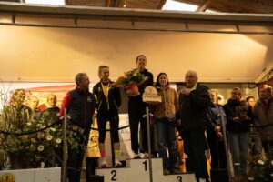 Podium féminin : la première féminine reçoit son trophée en bois gravé « 1re féminine ».